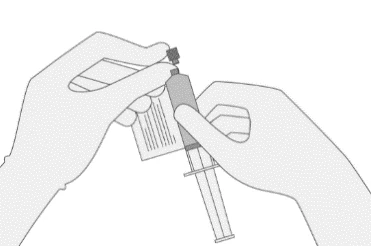 Due mani tengono una siringa con ago e un flaconcino di vetro per preparare la dose del farmaco tramite aspirazione del liquido