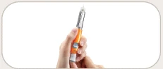Una mano tiene verticalmente una penna iniettiva di colore arancione e argento con l'ago esposto sulla punta superiore