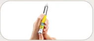 Una mano tiene verticalmente una penna iniettiva gialla e bianca con l'ago rivolto verso l'alto su sfondo bianco