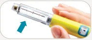 Una mano impugna un dispositivo medico cilindrico giallo con serbatoio trasparente e una freccia azzurra che punta verso il basso