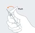 A hand holding a syringe with the needle pointing toward the