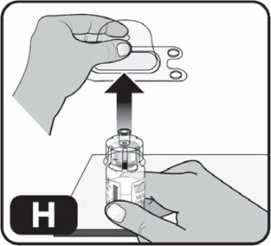 A hand holding a glass vial while the