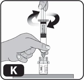 A hand holding a syringe vertically while the