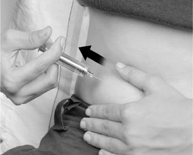 Ręka trzyma strzykawkę do podania leku podskórnie