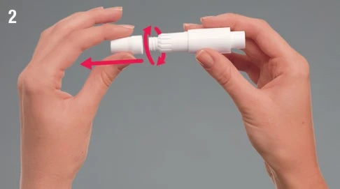 Two hands holding a white medical device with red arrows indicating a rotational movement and a lateral extraction movement