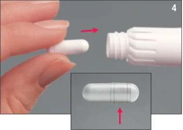 One hand holding a white capsule being inserted into a white cylindrical container, with an inset detail of the capsule itself