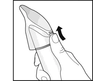 A hand holds a pen-shaped medical device with the thumb pressing downward