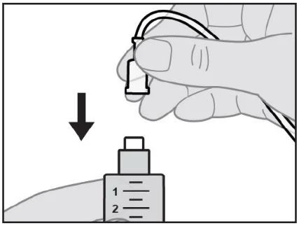 A hand holds a device with a small tube and pushes it downward toward a graduated container marked with the numbers 1 and 2