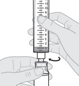 A hand holds a graduated syringe vertically while