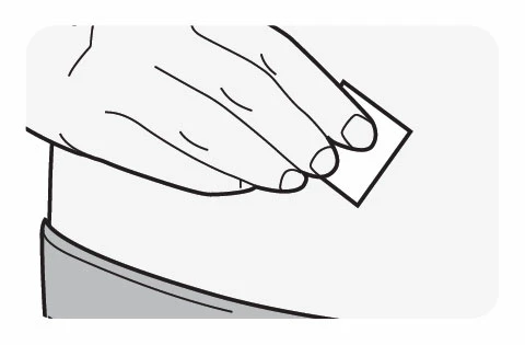 A hand holds a small rectangular patch above the skin of the