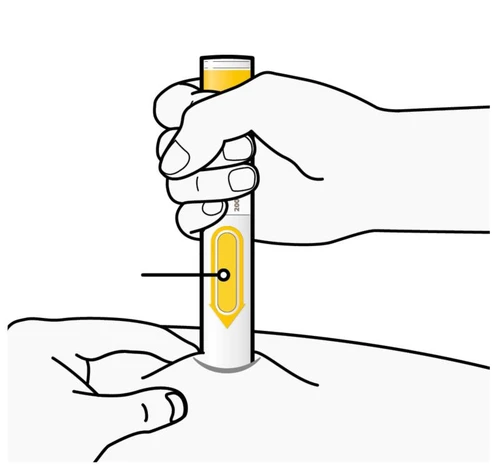 A hand holds vertically a white and yellow cylindrical medical device placing it on the skin of a