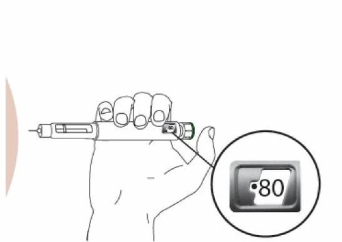 Una mano impugna un dispositivo medico orizzontale con un ingrandimento che mostra un display digitale con il numero 80