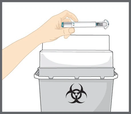 A hand holds a white injection pen above a gray biohazard waste container with a black biohazard symbol