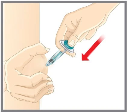 A hand holds a syringe with needle and liquid while the