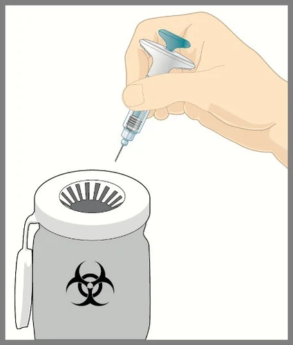 A hand holds a syringe with needle pointing toward the