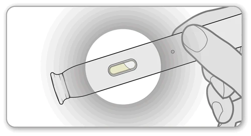 Una mano tiene un dispositivo medico allungato con una piccola finestra centrale che mostra un liquido giallastro all'interno