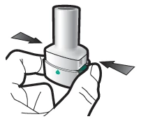 Two hands holding a white cylindrical medical device with black arrows indicating lateral pressure toward the center