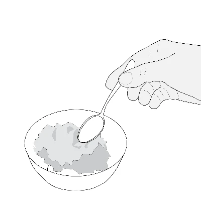 One hand holding a spoon immersed in a bowl containing a gray granular or powdery substance
