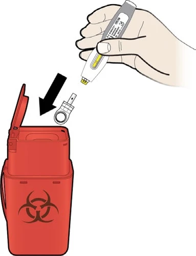 A hand inserting a white and yellow injection pen into a red biohazard waste container with a biological hazard symbol