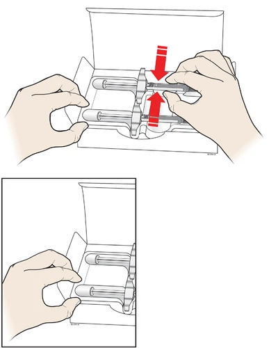 Two hands removing two ready-to-use syringes from the