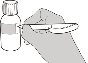 A hand holds an injection pen horizontally near a medicine vial with a striped cap and blank label