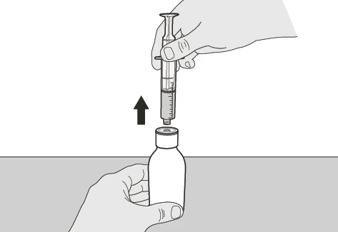 A hand holds a syringe and lifts it vertically upward toward the