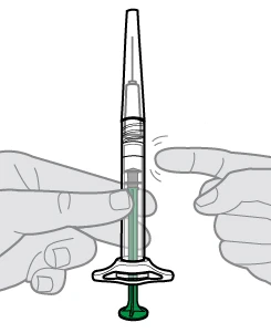 A hand holding a transparent syringe with a green plunger while a finger presses laterally on the barrel to push the liquid toward the tip