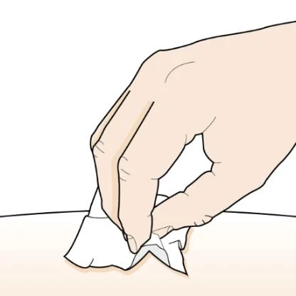 A hand holding a white tissue and gently placing it onto a light skin surface