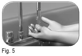 Two hands under an open tap washing hands under a water stream