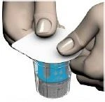 Two hands gently lifting a white circular disc above a small transparent container holding a blue liquid