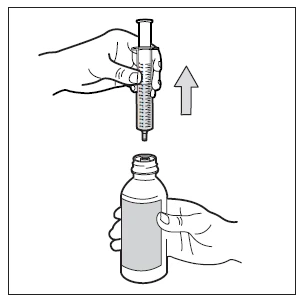 A hand holds a syringe with needle pointing downward while the