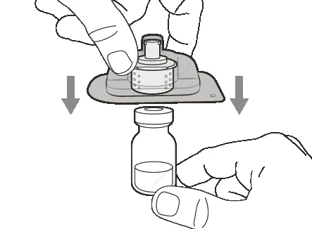 Two hands pressing an injection device downward to insert it into the cap of a glass vial with liquid