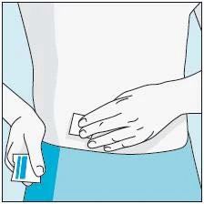 A hand holds a small white plaster while the