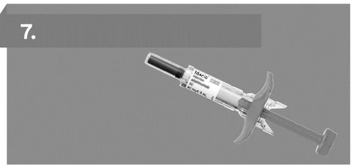 Single-use syringe with needle and protective cap positioned diagonally on a neutral gray background
