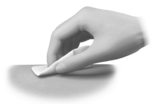 A hand gently applies an adhesive patch onto a smooth, light-colored skin surface