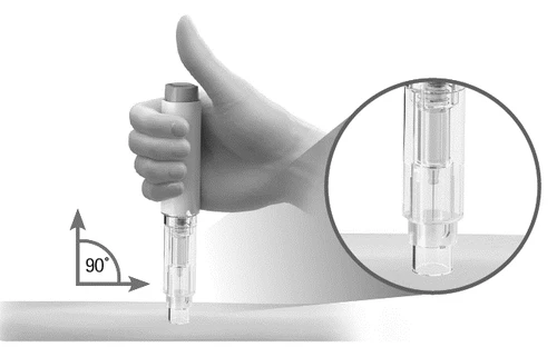 A hand holding a cylindrical medical device positioned at 90 degrees to the skin with a magnification of the tip detail