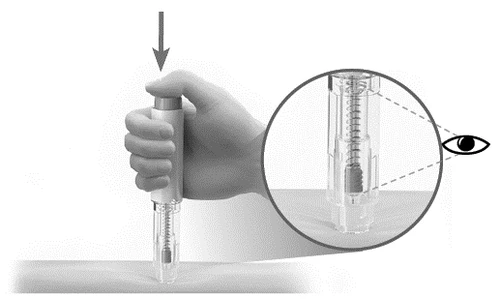 A hand pressing the upper button of a cylindrical medical device with a magnification showing the internal spring mechanism