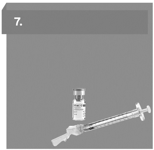 Transparent glass vial with label next to a syringe with attached needle on neutral gray background