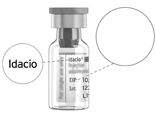 Transparent glass vial with Idacio label showing expiration date and lot number with two white circles connected by dashed lines