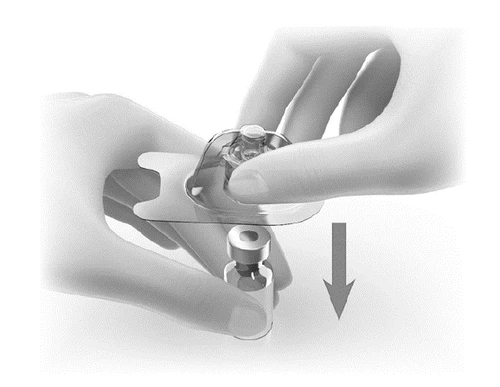 Two hands holding a transparent medical device above a small glass vial with a downward-pointing arrow