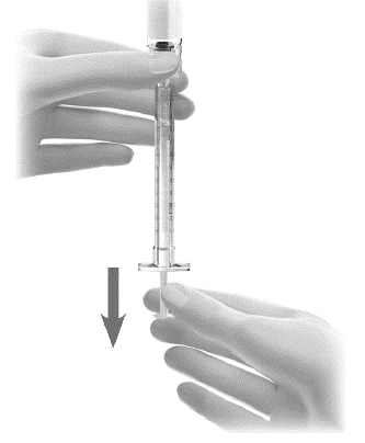A hand holding a transparent syringe vertically while the
