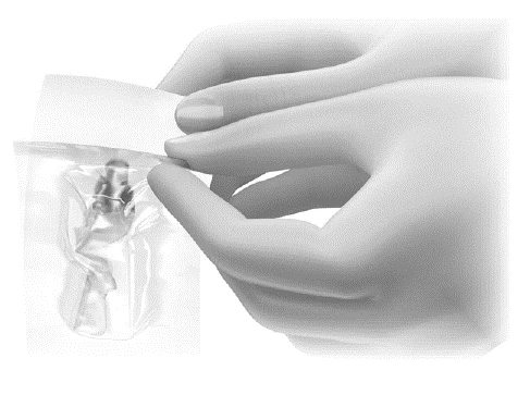 Two gloved hands carefully opening a transparent plastic pouch containing a liquid medication vial inside