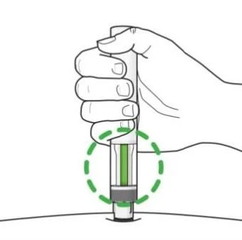 A hand holding a medical device vertically with a green indicator surrounded by a dashed circle above the skin