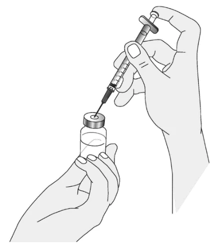 A hand holding a glass vial while the