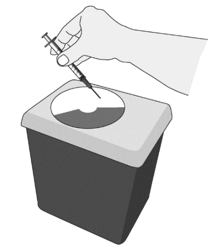 A hand holding a syringe with needle, inserting it into a disposal container for sharp and puncture-prone objects