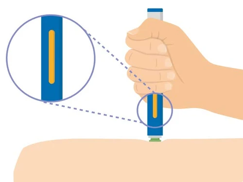A hand holding a blue and white medical device over an arm, with a close-up showing a yellow window on the body of the device
