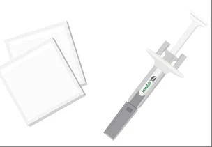 Gray and white syringe with green label next to two rectangular white sheets on a neutral background
