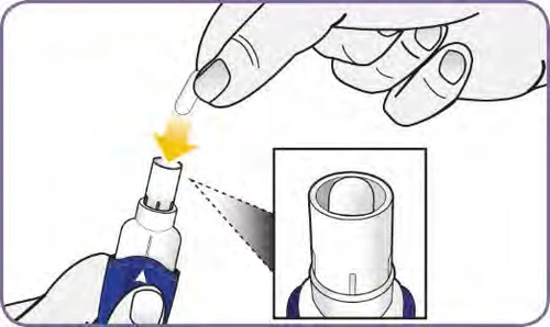 A hand inserting a small white cylinder into a white and blue medical device, with an inset magnified view of the component detail