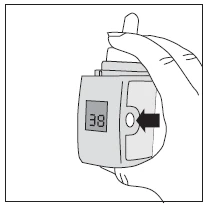 A hand holding a medical device with a digital display showing the number 38 and a black arrow pointing toward a circular button