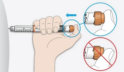 Una mano sostiene una pluma inyectable con una flecha azul que indica el movimiento de rotación hacia la izquierda y un círculo rojo con barra que prohíbe el sentido contrario